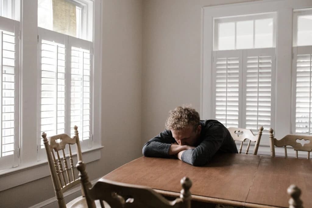 A man sits at a table depicting mental health for men